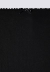 Tessuto nero con un motivo tessurizzato, caratterizzato da un bordo ondulato e un dettaglio a fiocco legato nella parte superiore.