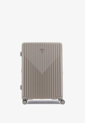 Valigia rigida di un beige chiaro con scanalature verticali, logo triangolare e quattro ruote girevoli per una facile mobilità.