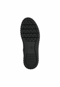 Semelle en caoutchouc noir avec un motif texturé présentant des motifs en zigzag et des bords surélevés ; comprend un logo circulaire près du centre.