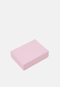 Růžová obdélníková krabička s hladkým povrchem, na které je vpředu zlaté logo s nápisem "COCCINELLE". Jednoduchý a minimalistický design.