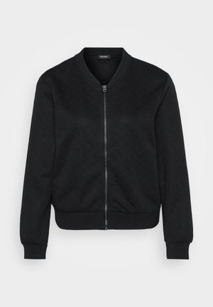 Black bomber jacket featuring a textured quilted pattern, zip closure, ribbed cuffs and hem, and a rounded neckline.
