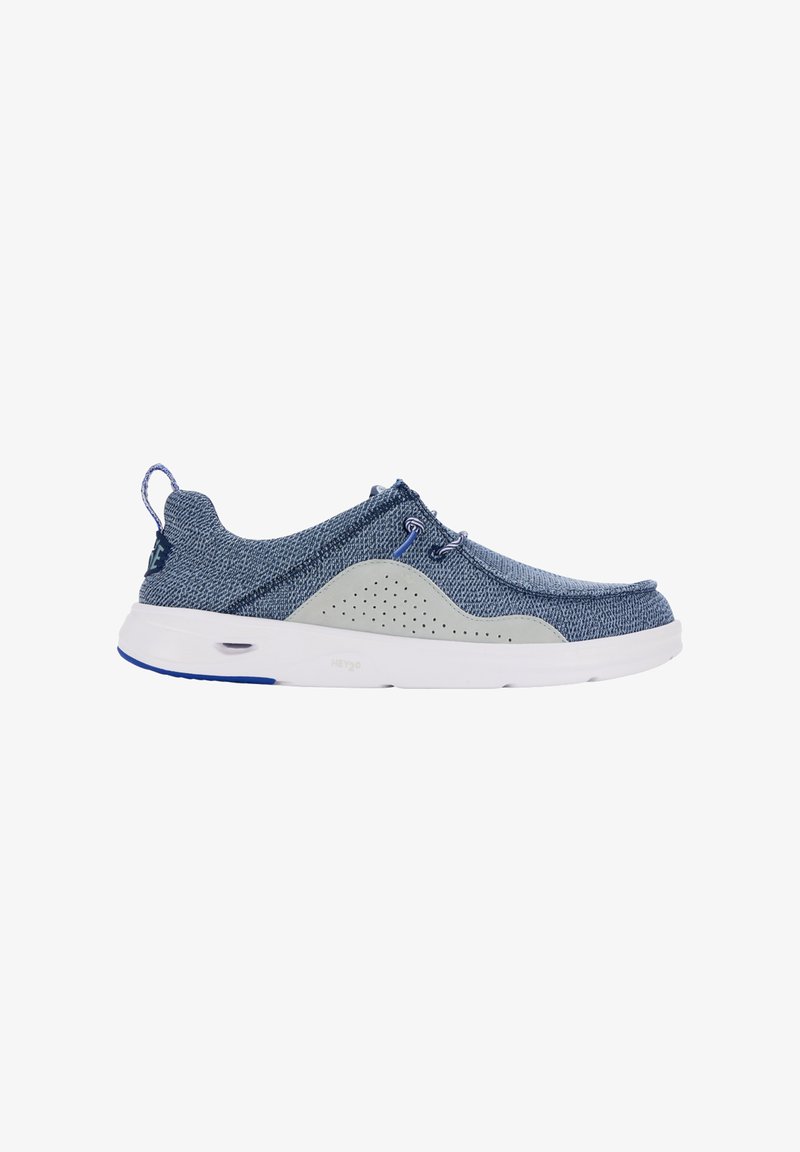 Scarpa slip-on in tessuto blu con dettagli grigi, dotata di un lato perforato per la traspirabilità, punta arrotondata e suola bianca con dettagli blu.