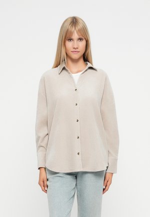 Beige button-up shirt with a collar, long sleeves, and a relaxed fit. Textured fabric with visible stitching and brown buttons.