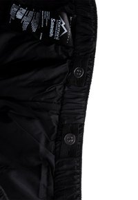 Shorts noirs d'extérieur avec une ceinture élastique, fermeture à bouton et étiquette à l'intérieur. Tissu lisse avec un léger éclat, présentant une couture froncée.