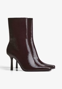 Burgundy patent leather ankle boots with a sleek, pointed toe, a fitted shaft, and a high stiletto heel. No visible hardware or embellishments.