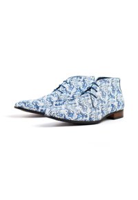 Blue and white patterned dress shoes with a chukka design, smooth texture, and brown wooden heel accents. Laces are dark blue.