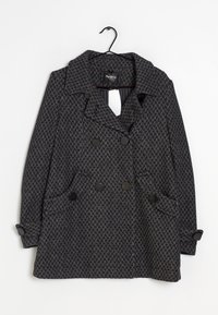 Abrigo gris texturizado con un patrón de espiga, de doble botonadura, grandes botones negros y bolsillos laterales. Presenta un cuello con muesca y mangas largas.