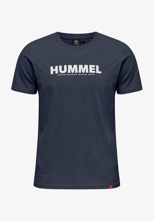 T-shirt en coton bleu marine avec un graphique blanc "HUMMEL" et le texte "SPORTSWEAR SINCE 1923". Manches courtes et coupe droite. Étiquette d'accent rouge.