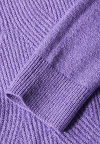 Tessuto di maglione viola lavorato a maglia con polsini a coste, caratterizzato da un design testurizzato di linee diagonali in rilievo e una finitura morbida e pelosa.