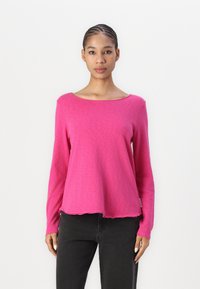 Magenta långärmad skjorta med vid halsringning och böjd nederkant. Tillverkad av mjukt tyg, med en avslappnad passform och minimal sömnadsdetaljer.