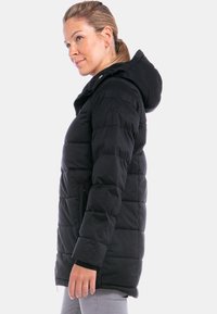 Schwarze Daunenjacke mit Kapuze, ausgestattet mit horizontalen Steppbereichen, zwei Seitentaschen und elastischen Bündchen für einen engen Sitz.