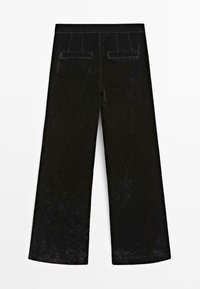 Pantalon large noir avec poches arrière à passepoil et coutures apparentes, étendu à plat sur un fond blanc.