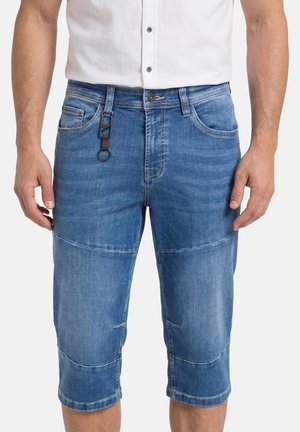 Mann trägt blaue, knielange Jeansshorts mit einem schwarzen Karabiner-Schlüsselanhänger, der an der Gürtelschlaufe befestigt ist.