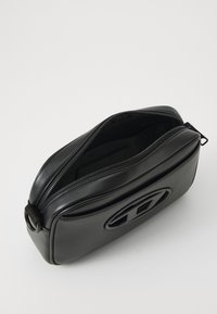 Black leather rectangular bag with a zipper closure, featuring a prominent embossed logo on the front and smooth texture.