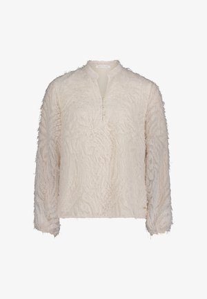 Kremowa bluzka z długim rękawem o teksturowanej, frędzlowanej powierzchni. Posiada kołnierz z wycięciem i trzy ozdobne guziki z przodu.