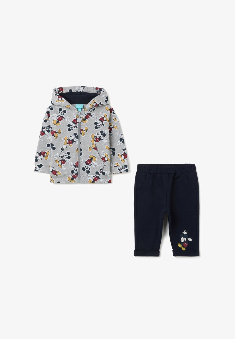 Grijze zip-up hoodie met kleurrijke Mickey Mouse print, gecombineerd met donkerblauwe broeken met geborduurd detail op het been. Zachte brei stoffen.