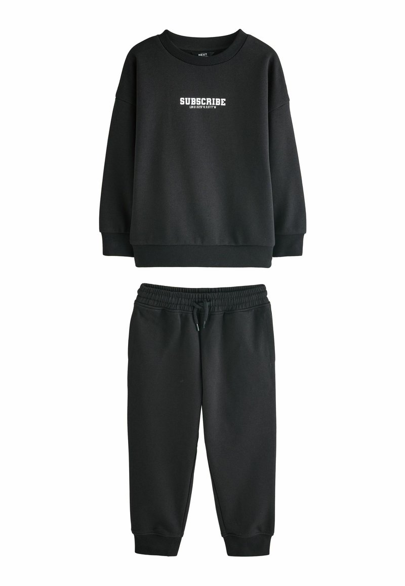 Sort sæt bestående af sweatshirt og joggers lavet af blødt stof. Sweatshirten har hvid "SUBSCRIBE" tekst; joggers har elastisk talje og manchetter.