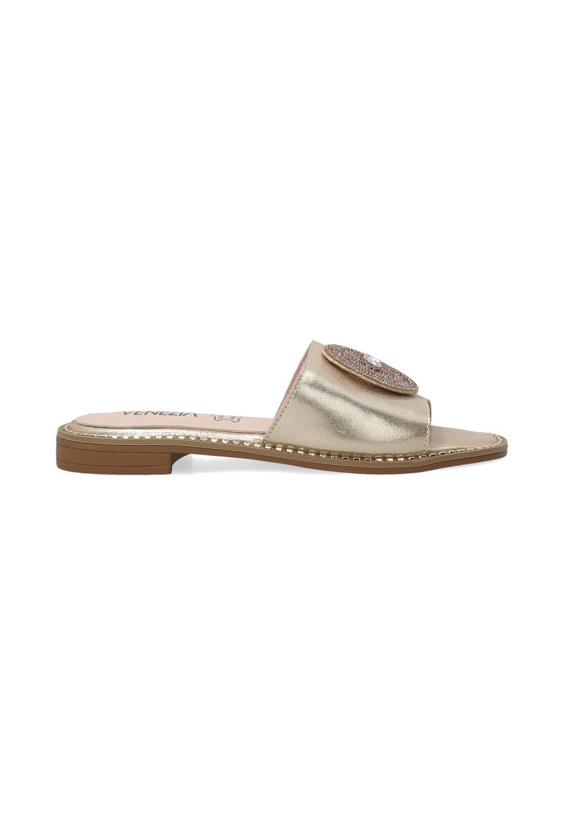 Guldmetallic slide sandal med en bred rem, dekoreret med en cirkulær rhinestone detalje, og en flad gummisål med dekorativ syning.