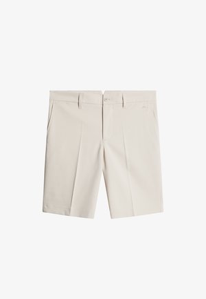 Beige shorts, valmistettu kevyestä kankaasta, jossa on tasainen etuosa, kaksi sivutaskua ja nappikiinnitys. Sujuva tekstuuri ja muotonsa mukainen istuvuus.