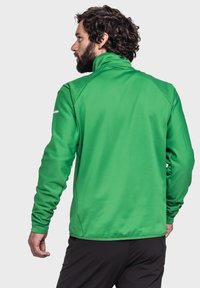 Grüne, leichte Jacke mit hohem Kragen, strukturiertem Stoff und langen Ärmeln. Besitzt kontrastierende Nähte und ein tailliertes Design.