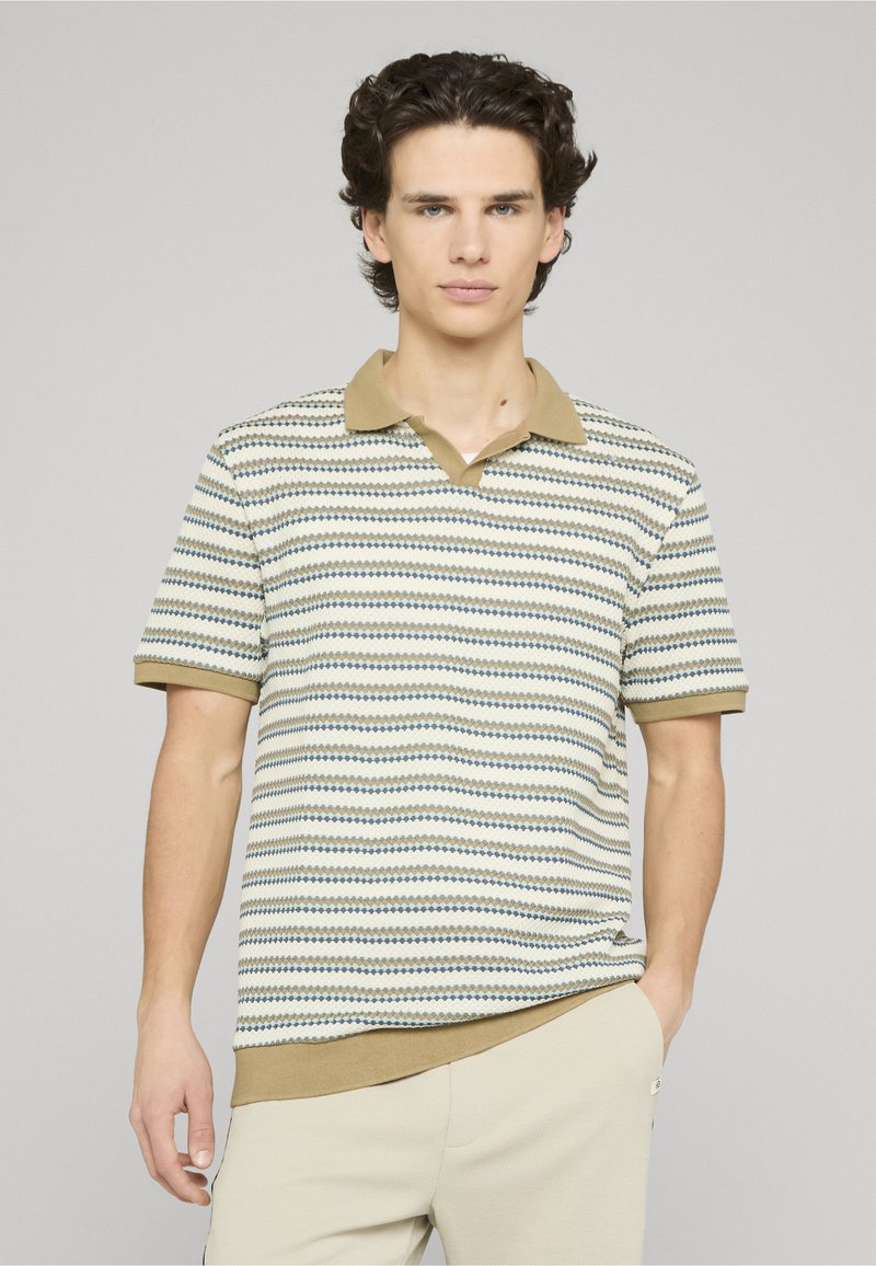 Polo à manches courtes couleur crème avec des rayures horizontales vertes et bleues, doté d'un col à revers et d'un ourlet côtelé. Tissu en mélange de coton.