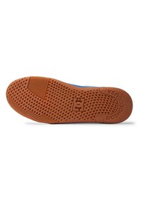 Gum rubber loopzool met een gestructureerd patroon, voorzien van een logo-afdruk. Voornamelijk bruine kleur met verhoogde geometrische vormen voor grip.