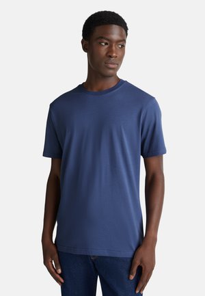 Camiseta de manga corta azul marino hecha de una suave mezcla de algodón, con escote redondo y un corte relajado. Textura suave sin patrones.