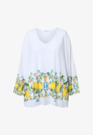 Weiße Tunika mit V-Ausschnitt und weiten Ärmeln. Sie hat ein lebhaftes gelbes Zitronen- und Blumenmuster am Saum. Aus glattem, leichtem Stoff.