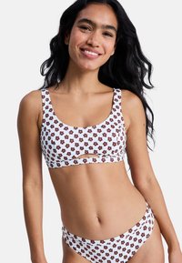 White bikini set with brown floral patterns. Top features wide straps and a front cut-out. Bottom has a matching design with medium coverage.