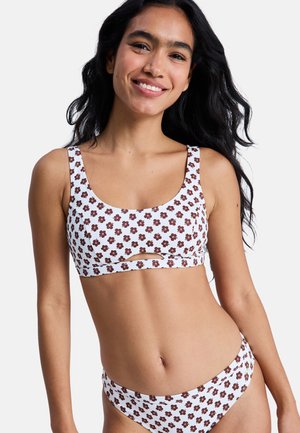 White bikini set with brown floral patterns. Top features wide straps and a front cut-out. Bottom has a matching design with medium coverage.