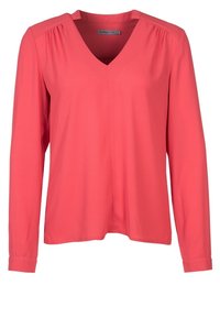 Korálová blůza s dlouhým rukávem a výstřihem do V, měkká na dotek, volného střihu s jemným nabíráním na ramenou. Hladká tkanina, žádné viditelné vzory ani akcenty.