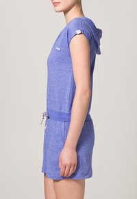 Fialové šaty s krátkým rukávem a kapucí, vyrobené ze měkké tkaniny, s stahovacími šňůrkami v pase a malým logem na hrudi.