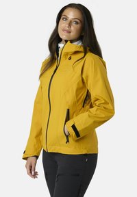 Giacca impermeabile gialla con zip frontale, dettagli neri, cappuccio regolabile, due tasche laterali con zip e design aderente.