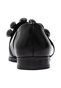 Czarne skórzane buty o gładkim, teksturowanym wykończeniu, z niskim obcasem i dekoracyjnymi, zaokrąglonymi akcentami z tyłu, charakteryzujące się minimalistycznym designem.