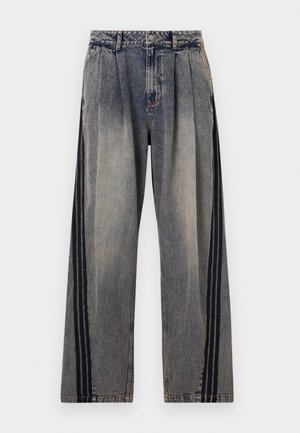 Τζιν ψηλόμεσο με ξεθωριασμένο γκρι χρώμα, πιέτες και μαύριες κάθετες ρίγες κατά μήκος των εξωτερικών πλευρών κάθε ποδιού.