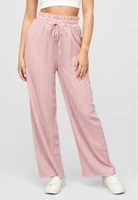 Pantalons à jambes larges rose clair en tissu texturé, avec une taille froncée, une fermeture à cordon et des poches latérales.