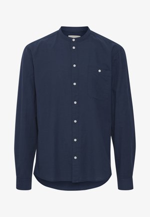 Tumedast sinise värviga pikkade varrukatega särk, millel on bändikaelus, esitasku, nööbiga kinnitamine ja ümar hem. Valmistatud pehmest kangast.