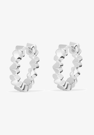 Silberne Creolen mit einem gewellten Randdesign, ausgestattet mit einer polierten Oberfläche und einem sicheren Verschluss. Minimalistisch und geometrische Form.