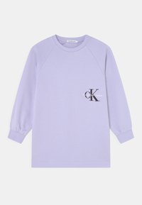 Levandulová mikina s dlouhými raglánovými rukávy, žebrovanými manžetami a kulatým výstřihem. Na hrudi se nachází vytištěné černé logo.