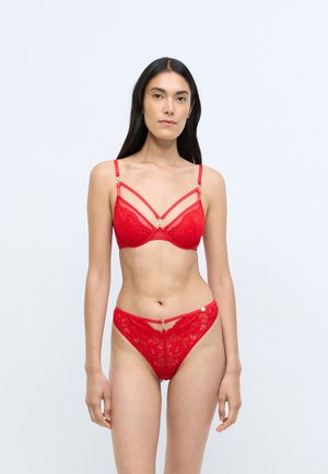 Conjunto de lencería de encaje rojo que incluye un sujetador con detalles dorados y tirantes finos, y unas braguitas de talle alto a juego con intrincados patrones florales.