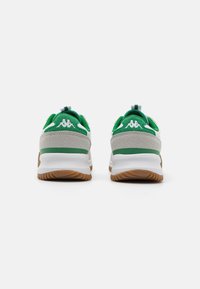 Zapatillas deportivas verdes y blancas con una parte superior de ante texturizado, suela de goma y una tira trasera para facilitar el calzado. Presentan un logo en blanco en el talón.