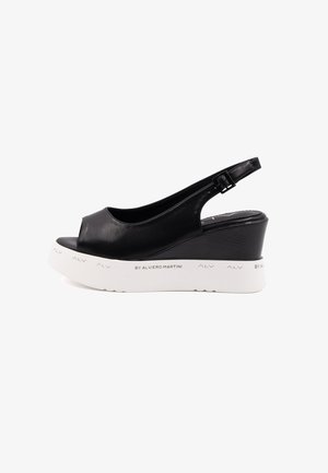 Sandale à talon compensé en cuir noir avec bout ouvert et bride à l'arrière. Présente un talon noir texturé et une plateforme blanche avec des détails de logo.