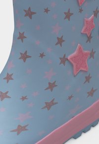 Μπλε λαστιχένια μπότα με ροζ σχέδια αστεριών και ανάγλυφα ροζ αστέρια κοντά στον αστράγαλο, με ροζ περίγραμμα σόλας.