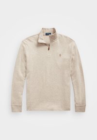 Beige långärmad polo med kvartdragkedja, med en liten broderad logotyp på vänster bröst och ribbade muddar. Mjuk tygstruktur.