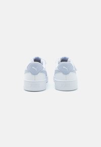 Hvite sneakers med lysegrå detaljer, rund tå, polstret krave og teksturerte materialer. "PUMA"-merke på hælen.