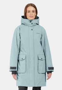 Ljusblå vattentät parka med huva, tryckknappar, två framfickor och svarta detaljer vid ärmsluten. Designad för användning i kallt väder.