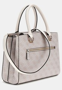 Beige mønsteret håndtaske med to topphåndtag og en aftagelig skulderrem. Har en lynlåslomme foran og detaljer i guldfarvet hardware.