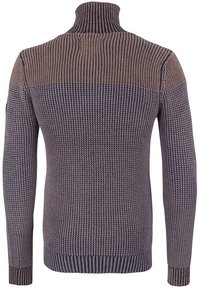 Chunkig stickad tröja i nyanser av beige och marinblå, med högt nacke, ribbad manschetter och mönstrad textur. Lämplig för avslappnad användning.