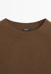 Pull marron en maille à col rond avec col côtelé et étiquette Massimo Dutti cousue à l'intérieur de l'encolure.