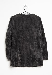 Grå faux fur frakke med en blød tekstur, lange ærmer og en rund halsudskæring, hængende på en sort trådophæng mod en hvid baggrund.